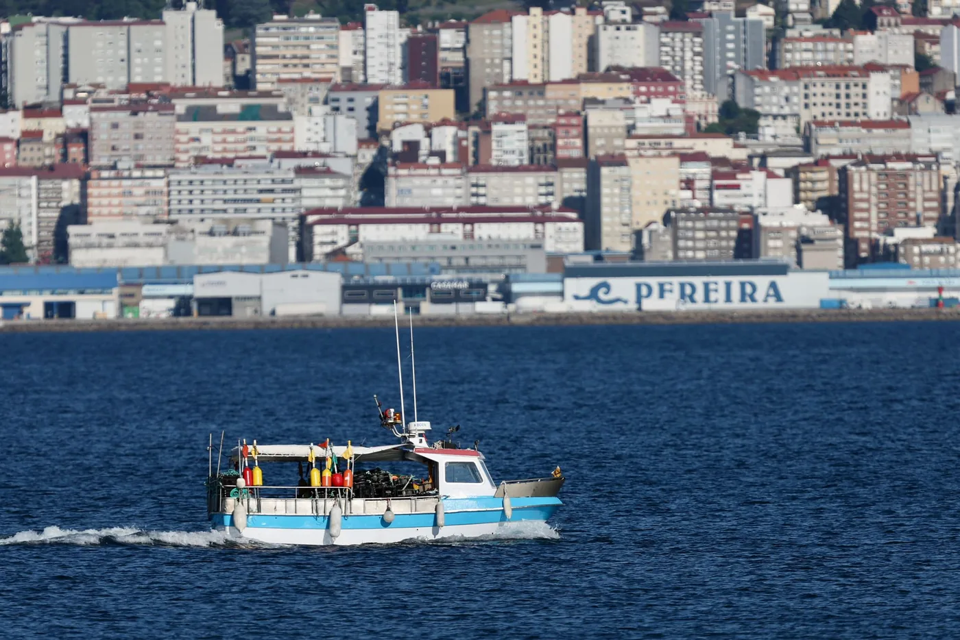 Barco pesquero en el puerto de Vigo con la ciudad al fondo