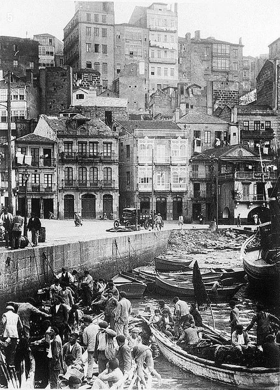 Fotografía histórica en blanco y negro de pescadores descargando el pescado en la lonja de Vigo a comienzos del siglo XX