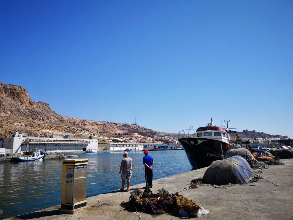 Puerto pesquero de Almería con barcos y redes en el muelle