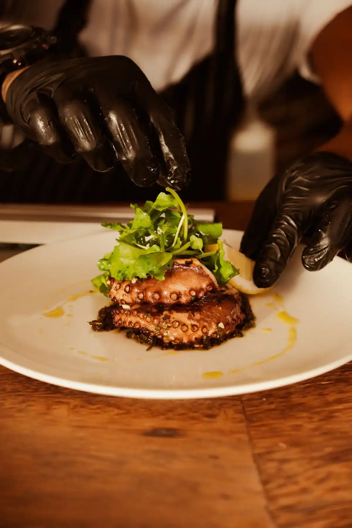 Chef emplatando un plato gourmet de pulpo en un restaurante